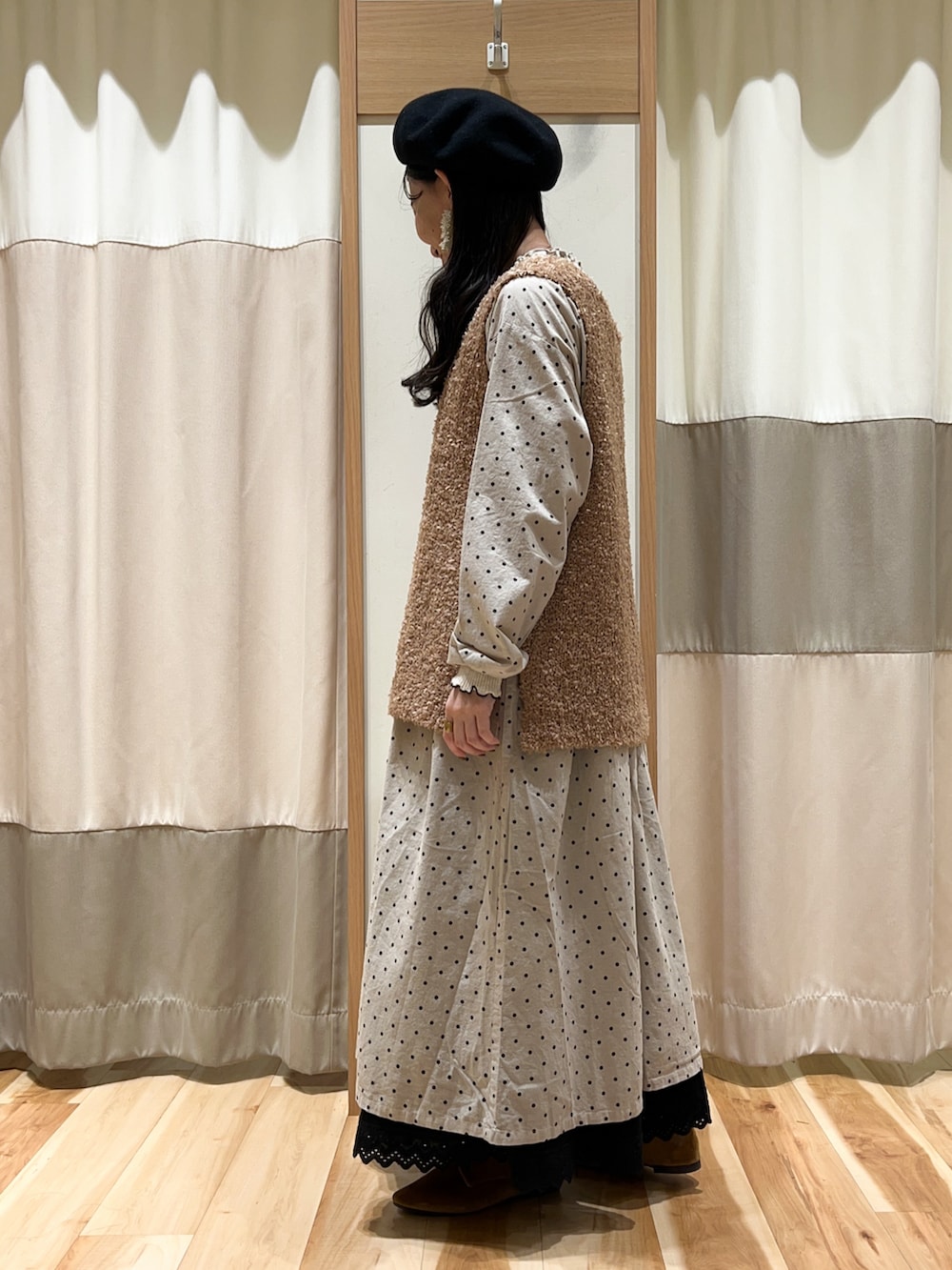 ベージュ系のベスト、ホワイト系のTシャツ/カットソー、ホワイト系のワンピースを着用したレディースの秋コーディネートの3枚目の写真