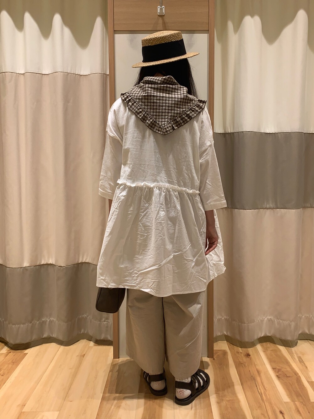 ベージュ系のTシャツ/カットソー、ブラウン系のショルダーバッグ、ブラウン系のサンダルを着用したレディースの春コーディネートの5枚目の写真