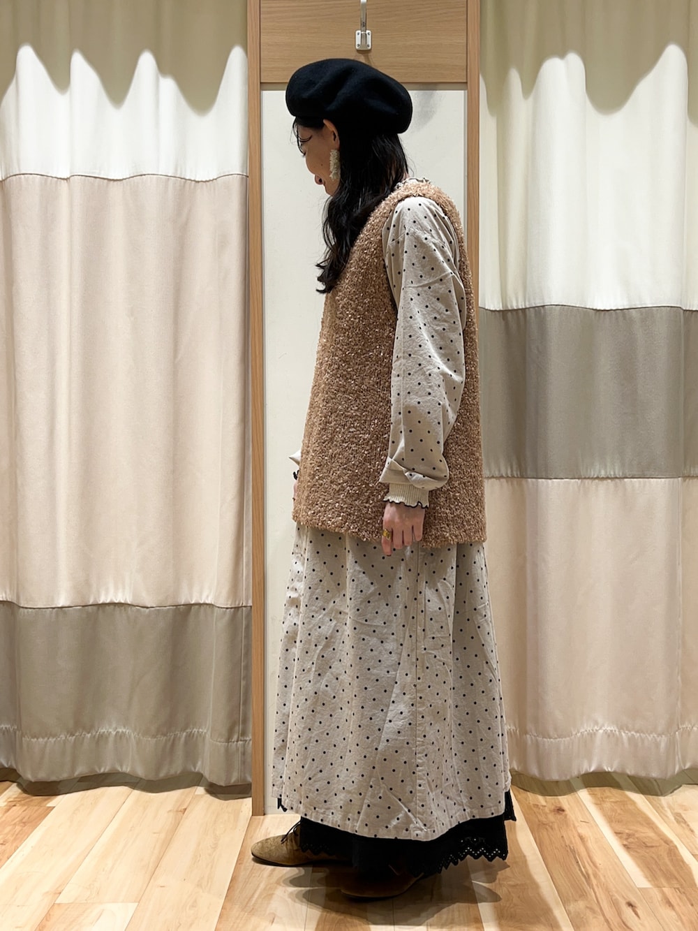 ベージュ系のベスト、ホワイト系のTシャツ/カットソー、ホワイト系のワンピースを着用したレディースの秋コーディネートの2枚目の写真