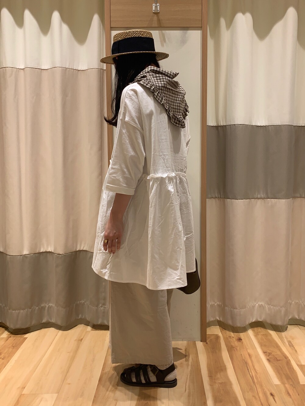 ベージュ系のTシャツ/カットソー、ブラウン系のショルダーバッグ、ブラウン系のサンダルを着用したレディースの春コーディネートの4枚目の写真