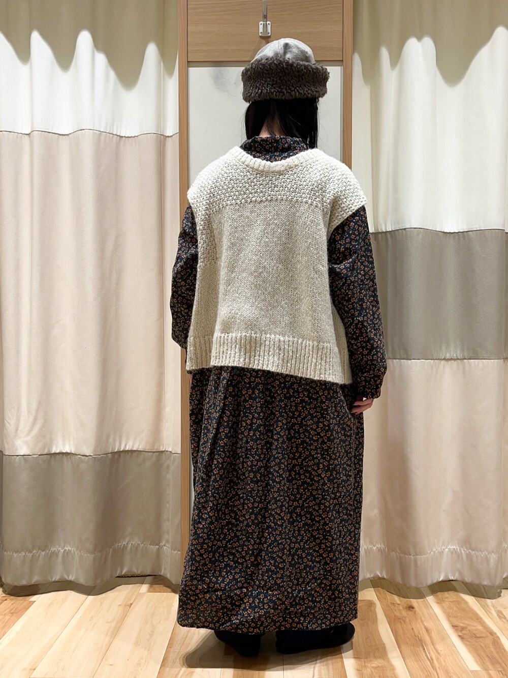 ホワイト系のベスト、ブラック系のワンピース、ブルー系のその他パンツを着用したレディースの冬コーディネートの5枚目の写真