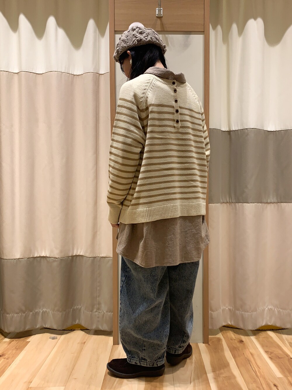 ベージュ系のニット/セーター、ブラウン系のチュニック、ブルー系のデニムパンツを着用したレディースの冬コーディネートの4枚目の写真