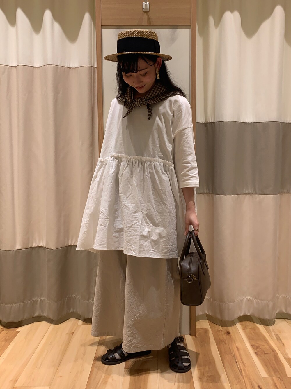 ベージュ系のTシャツ/カットソー、ブラウン系のショルダーバッグ、ブラウン系のサンダルを着用したレディースの春コーディネートの2枚目の写真