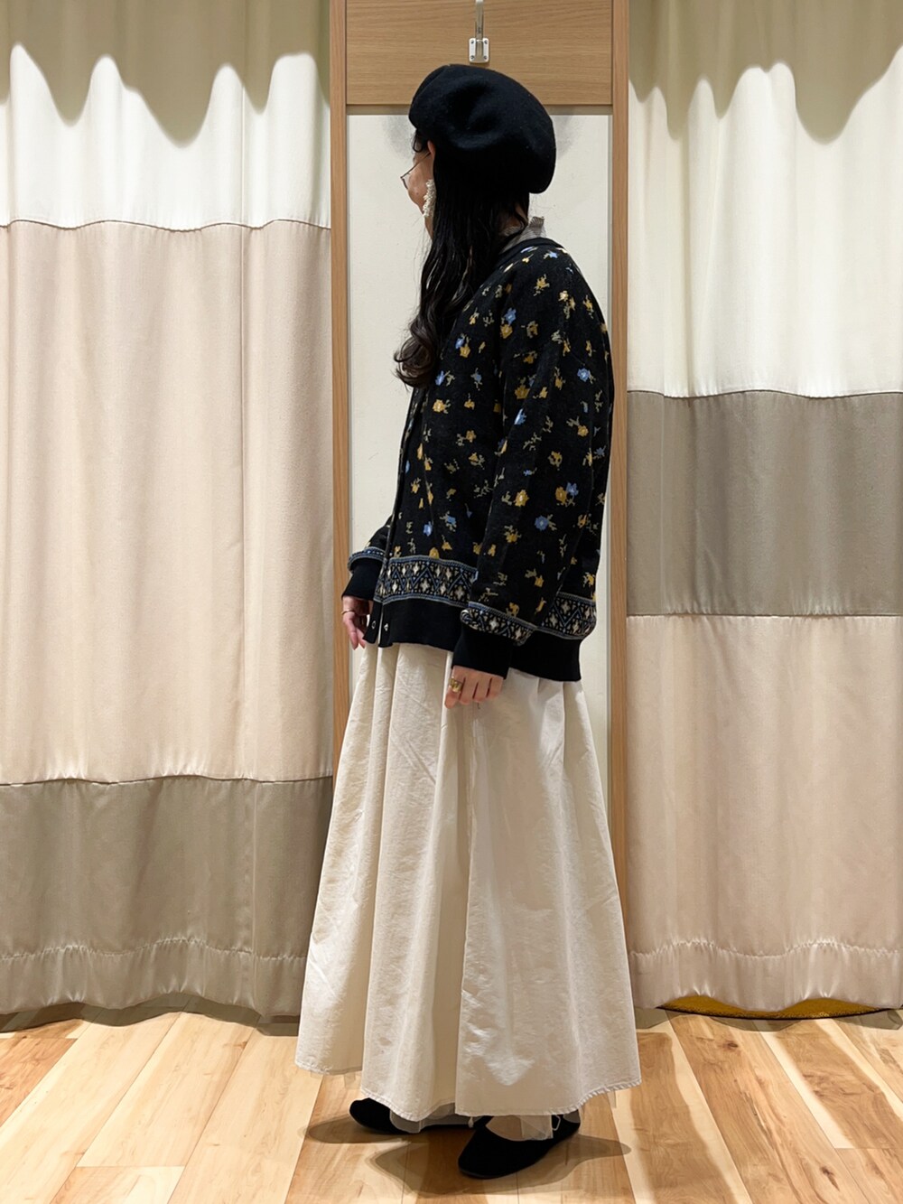 ブルー系のシャツ/ブラウス、ホワイト系のスカート、ブラック系のカーディガン/ボレロを着用したレディースの冬コーディネートの2枚目の写真