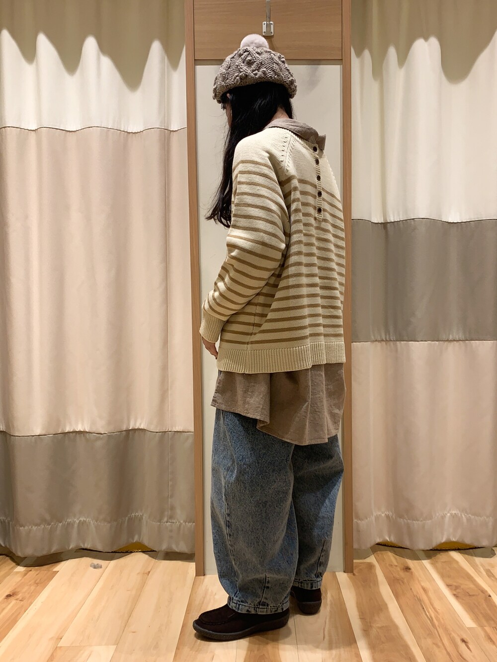 ベージュ系のニット/セーター、ブラウン系のチュニック、ブルー系のデニムパンツを着用したレディースの冬コーディネートの3枚目の写真