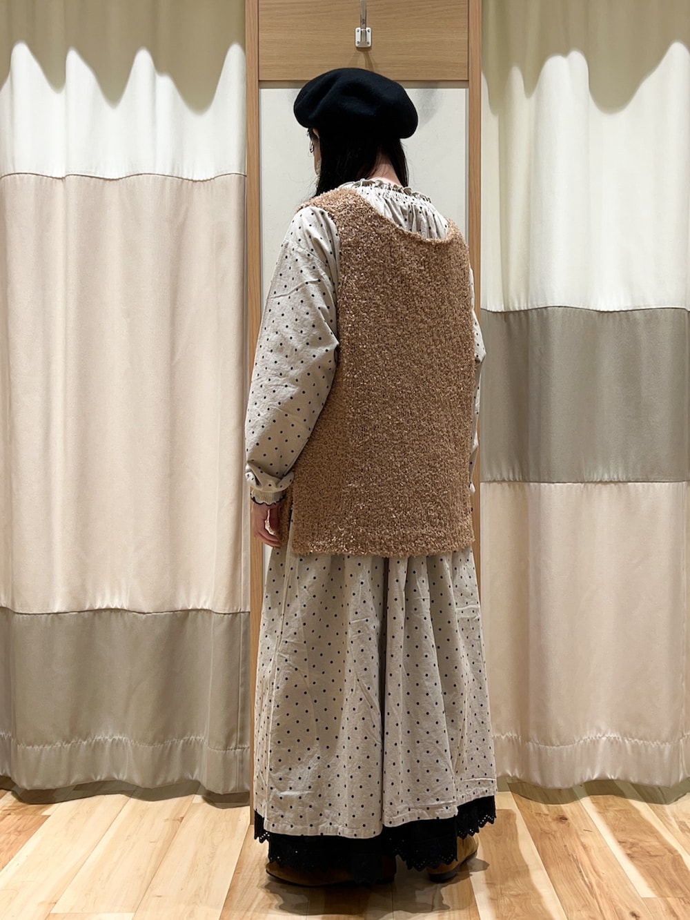 ベージュ系のベスト、ホワイト系のTシャツ/カットソー、ホワイト系のワンピースを着用したレディースの秋コーディネートの4枚目の写真