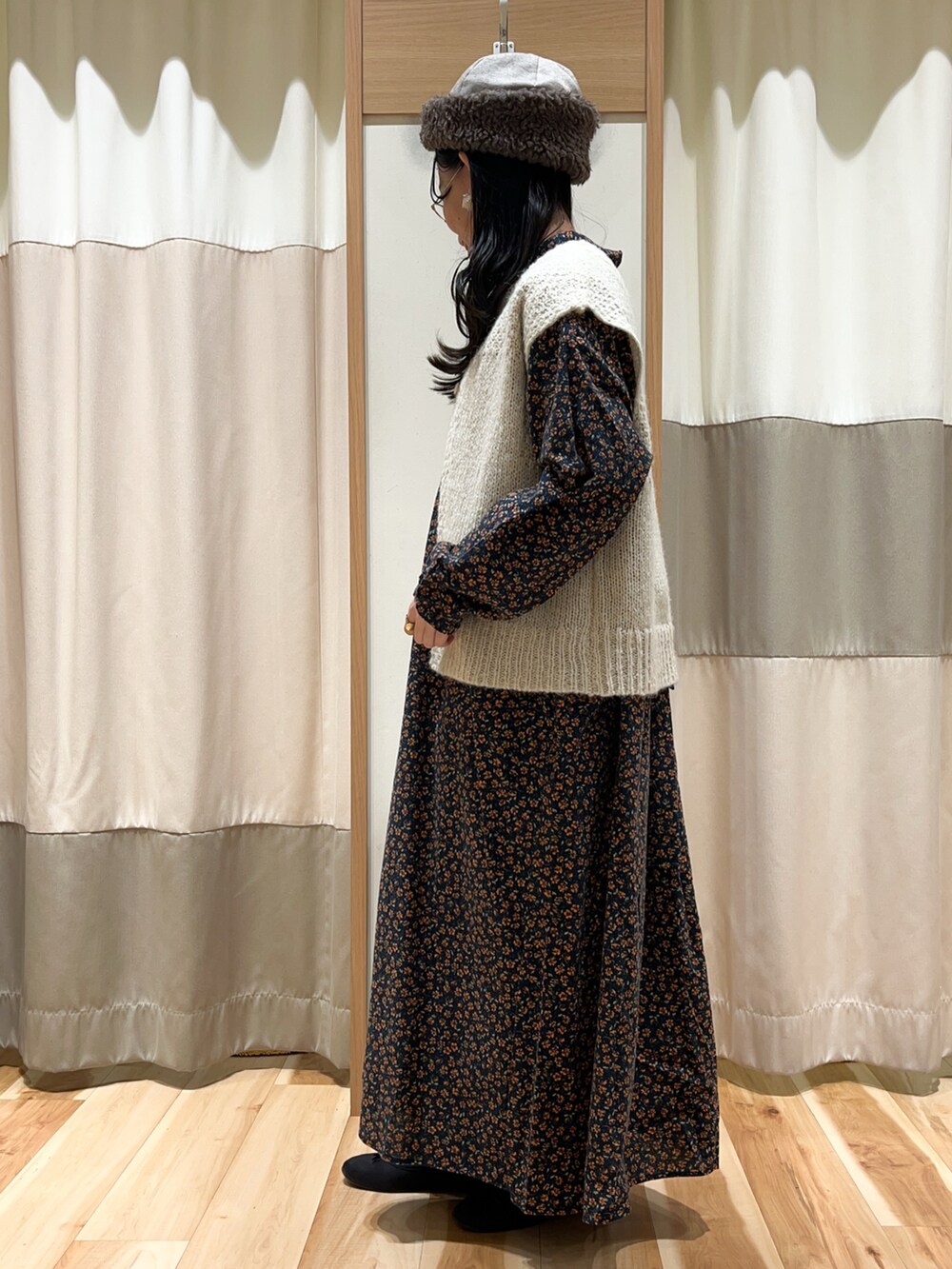 ホワイト系のベスト、ブラック系のワンピース、ブルー系のその他パンツを着用したレディースの冬コーディネートの2枚目の写真