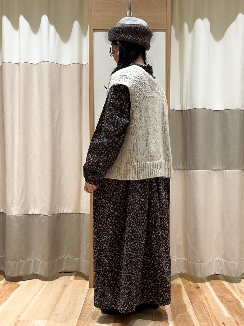 ホワイト系のベスト、ブラック系のワンピース、ブルー系のその他パンツを着用したレディースの冬コーディネートの3枚目の写真