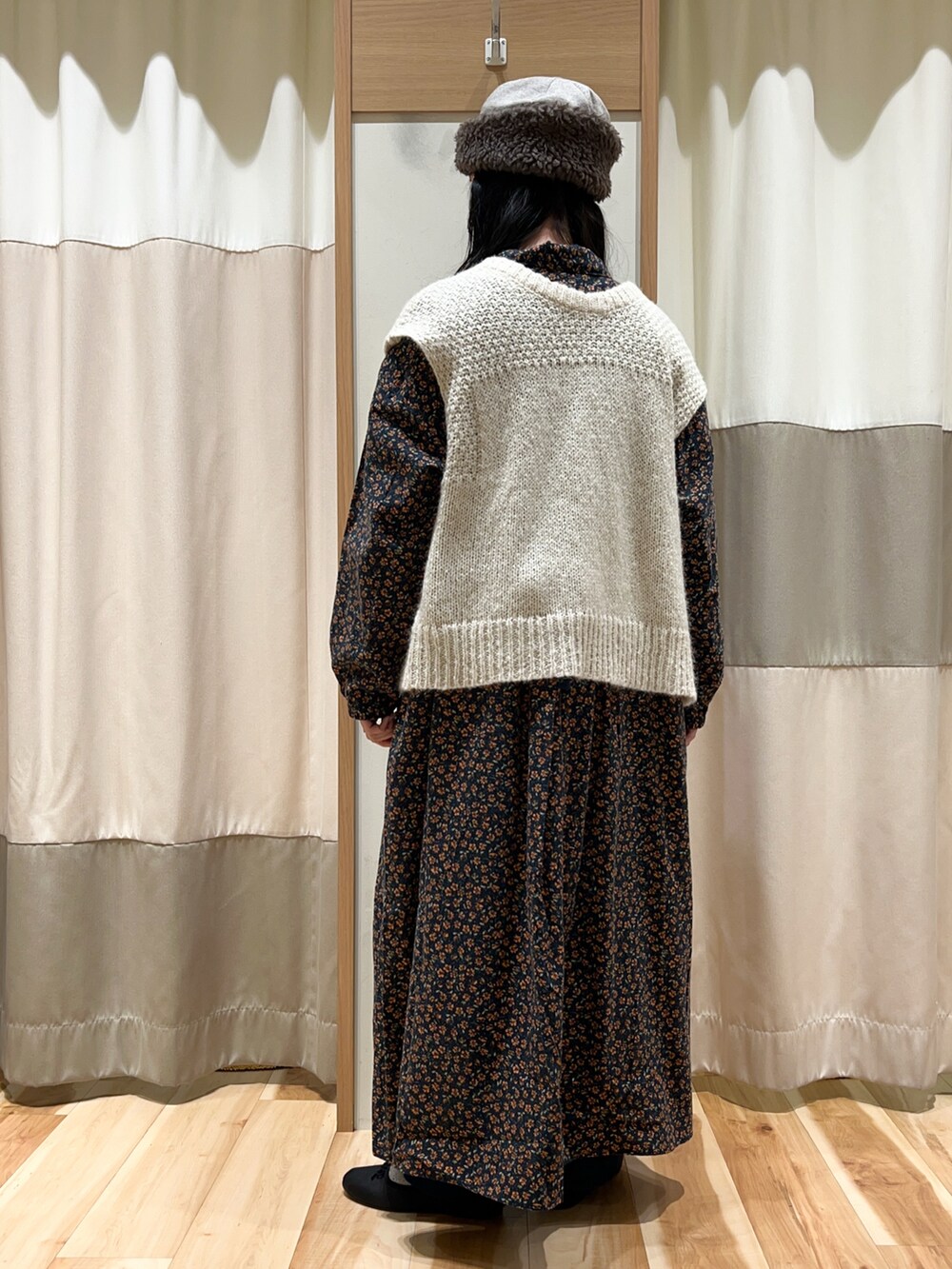 ホワイト系のベスト、ブラック系のワンピース、ブルー系のその他パンツを着用したレディースの冬コーディネートの4枚目の写真