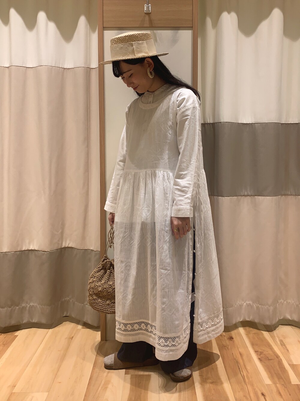 ホワイト系のシャツ/ブラウス、イエロー系のサンダル、ベージュ系のエコバッグ/サブバッグを着用したレディースの春コーディネートの2枚目の写真