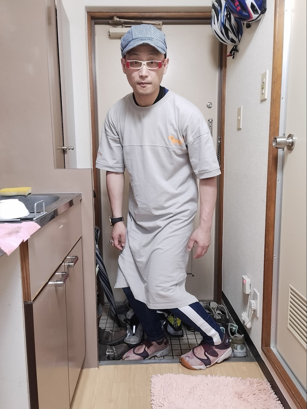 グレー系のTシャツ/カットソー、ブルー系のデニムパンツ、ピンク系のサンダルを着用したメンズの夏コーディネートの2枚目の写真