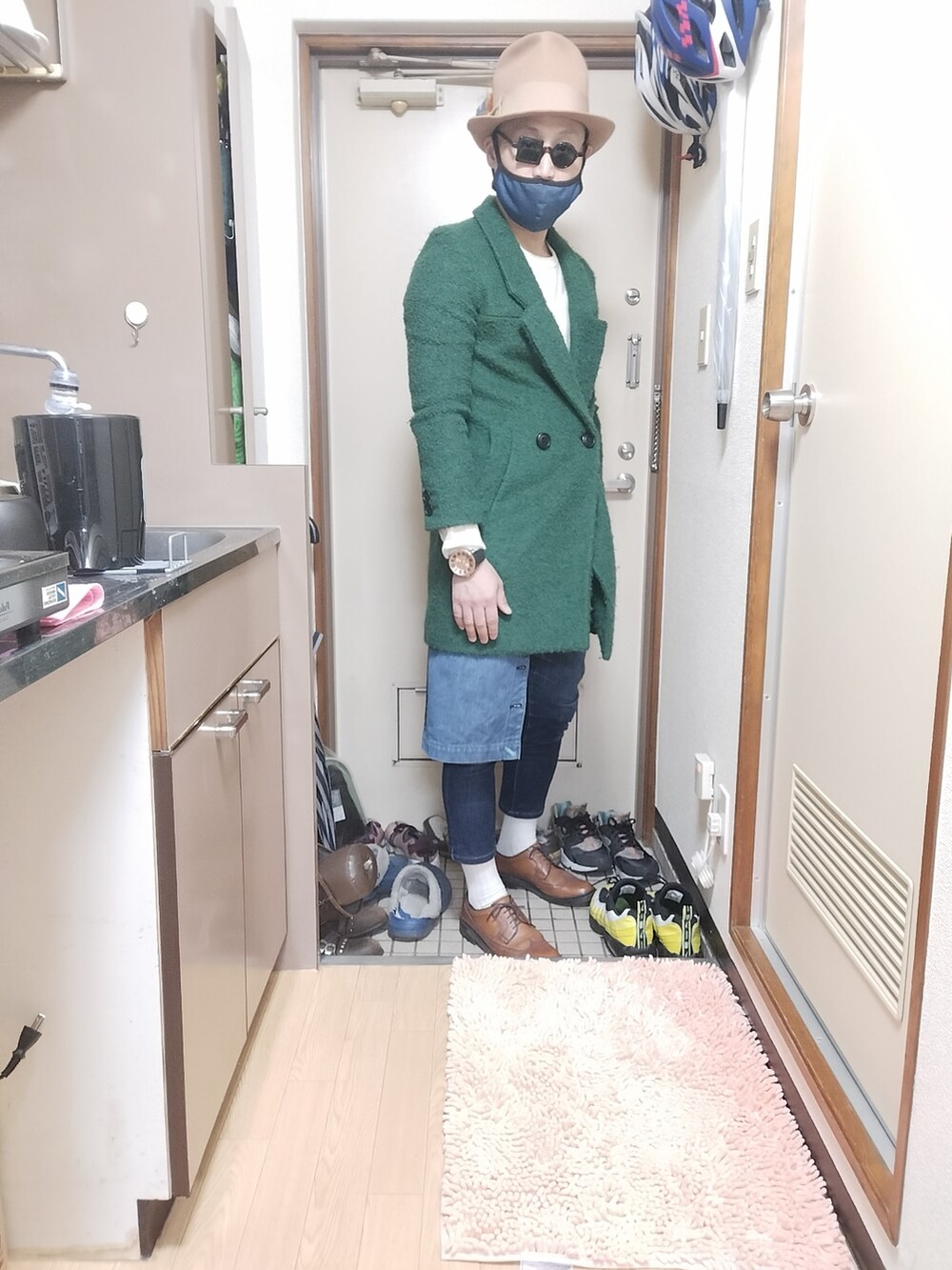 ブラウン系のローファー、グリーン系のチェスターコート、ブルー系のエプロンを着用したメンズの冬コーディネートの3枚目の写真