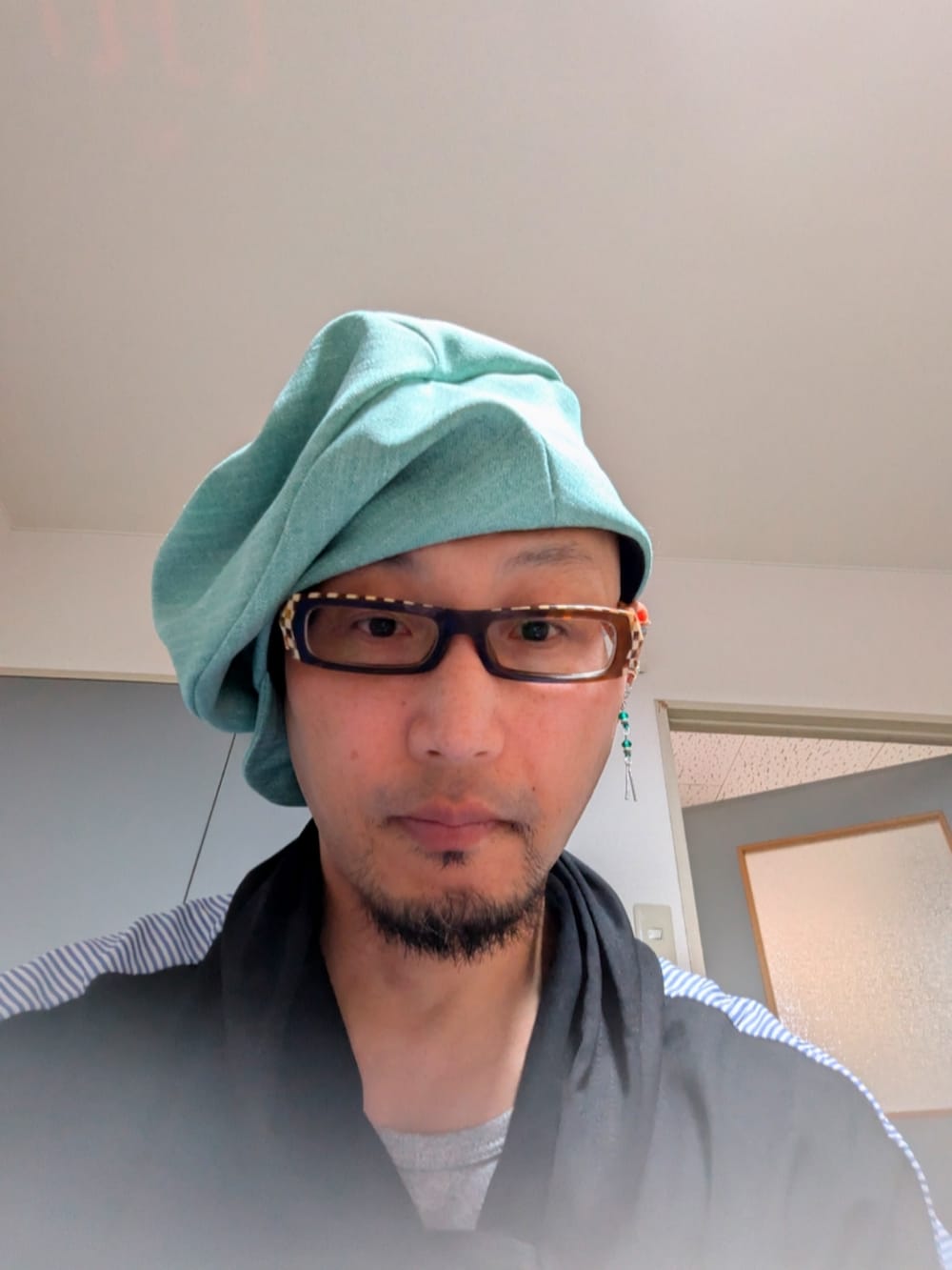 グリーン系の帽子を着用したメンズの春コーディネートの2枚目の写真