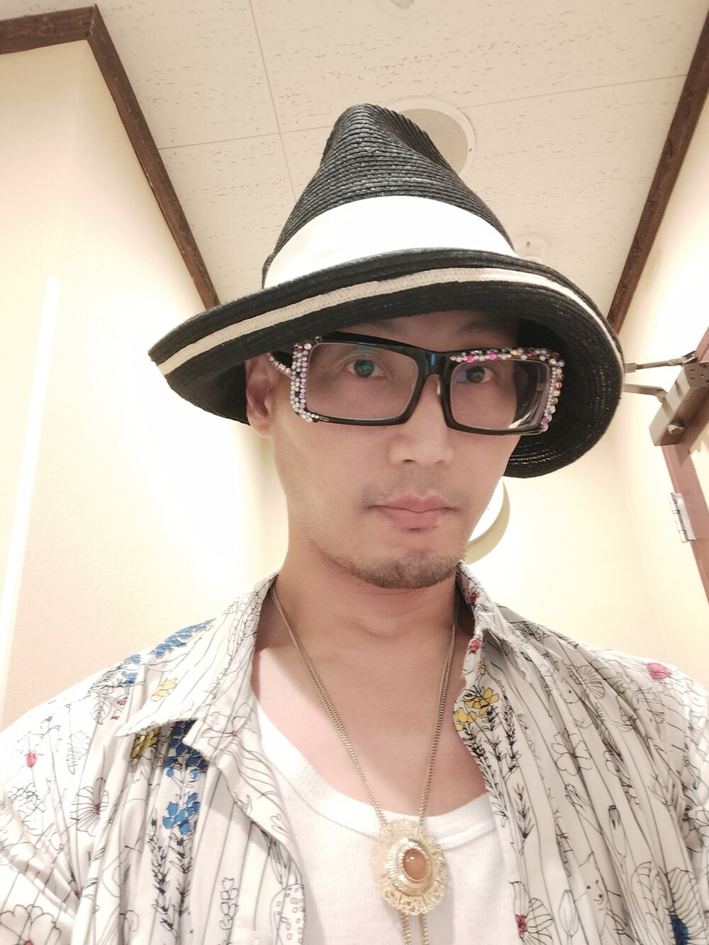 ホワイト系のシャツワンピース、オレンジ系のその他パンツ、グリーン系のハットを着用したメンズの夏コーディネートの4枚目の写真