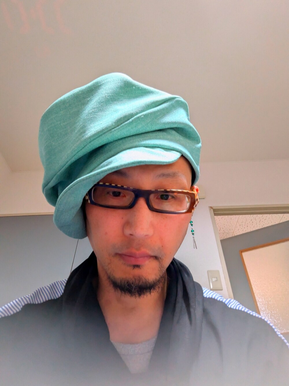 グリーン系の帽子を着用したメンズの春コーディネートの4枚目の写真