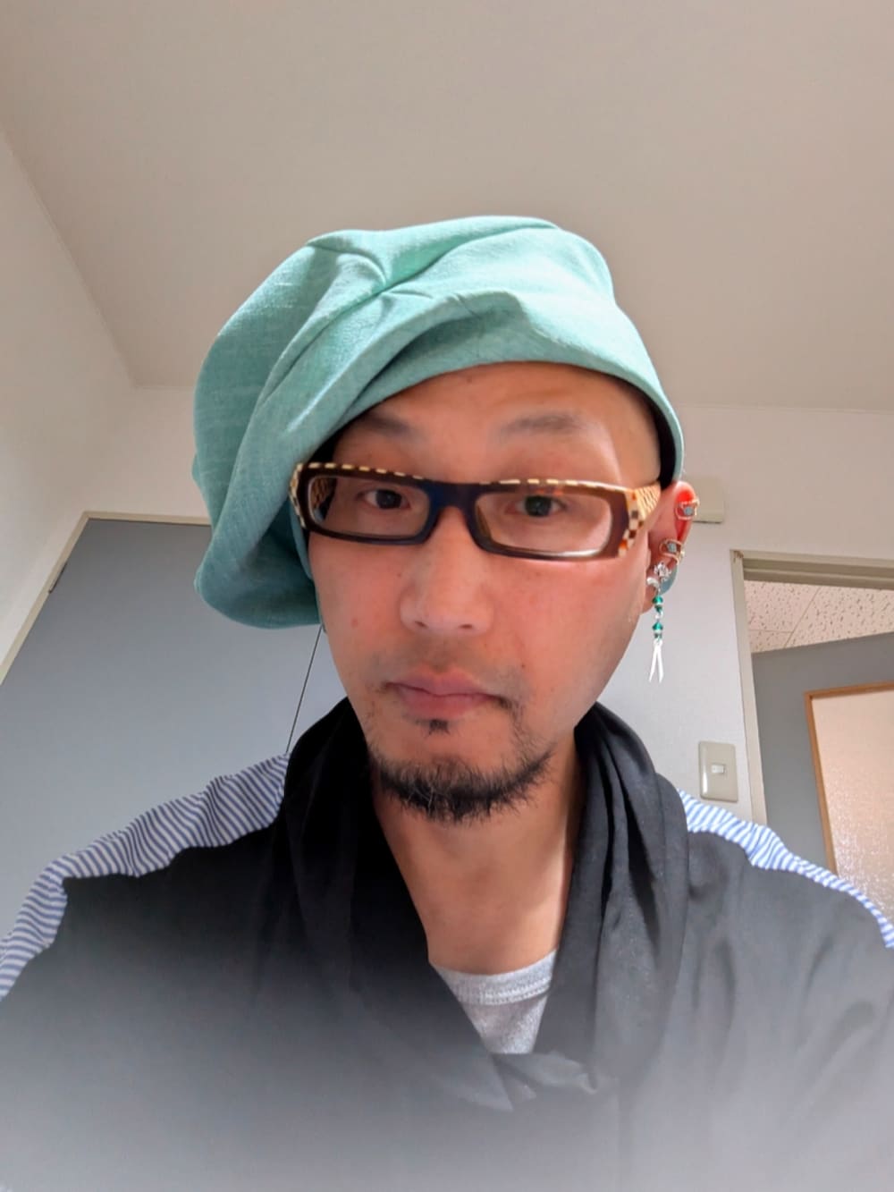 グリーン系の帽子を着用したメンズの春コーディネートの3枚目の写真