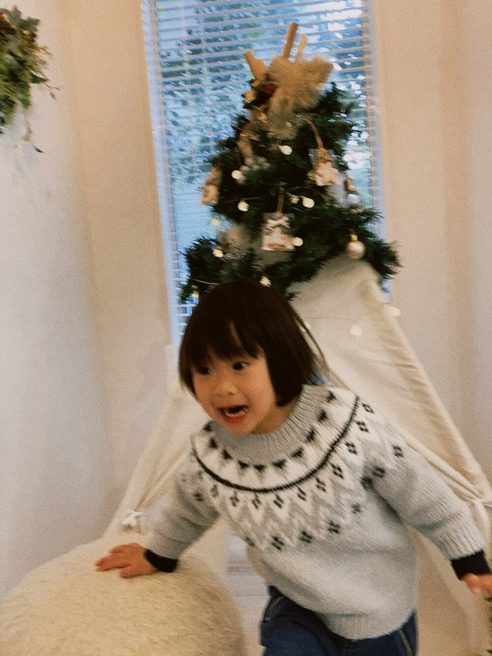 グレー系のニット/セーター、ブルー系のデニムパンツを着用したキッズの冬コーディネートの2枚目の写真