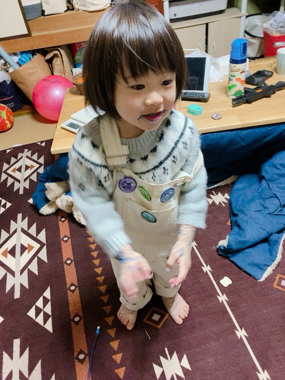 ホワイト系のサロペット/オーバーオール、グレー系のニット/セーターを着用したキッズの冬コーディネートの2枚目の写真