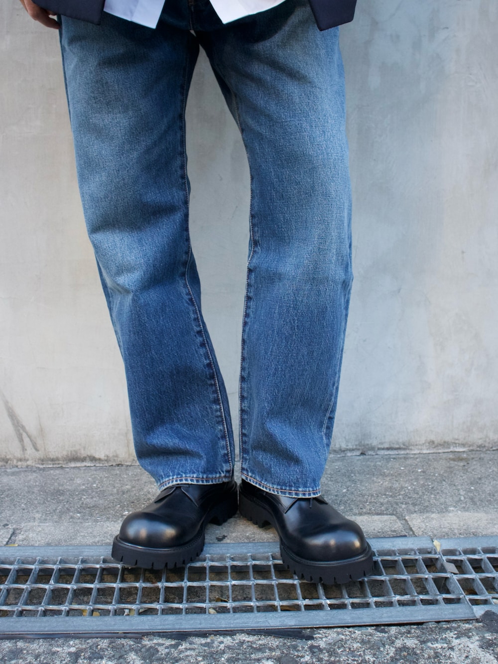 ブルー系のショルダーバッグ、ブラック系のドレスシューズを着用したメンズの春コーディネートの3枚目の写真