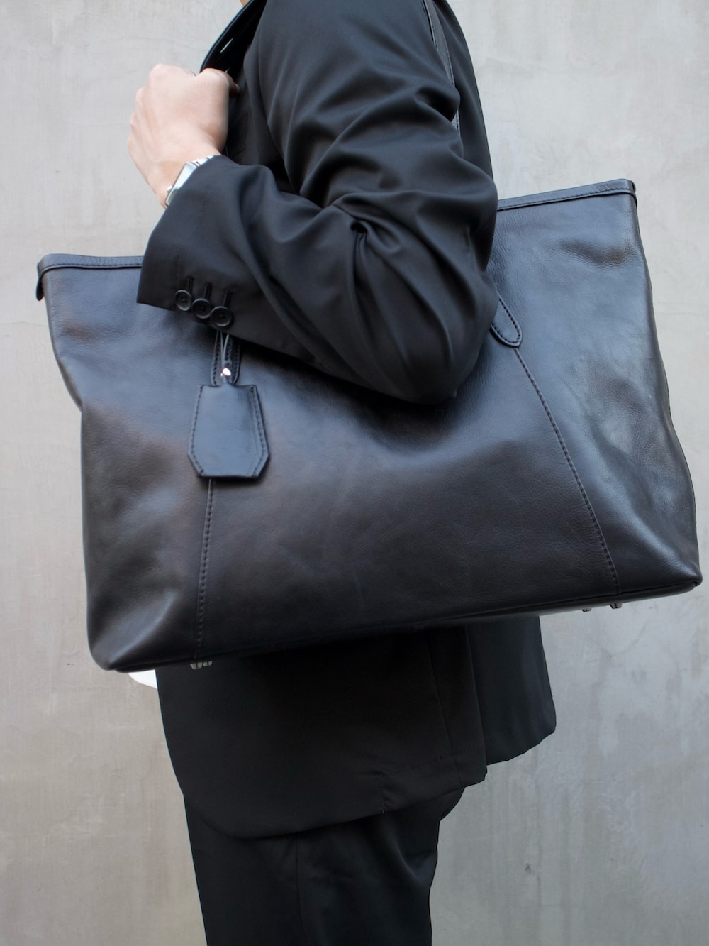 ブラック系のトートバッグ、ブラック系のスリッポンを着用したメンズの春コーディネートの2枚目の写真