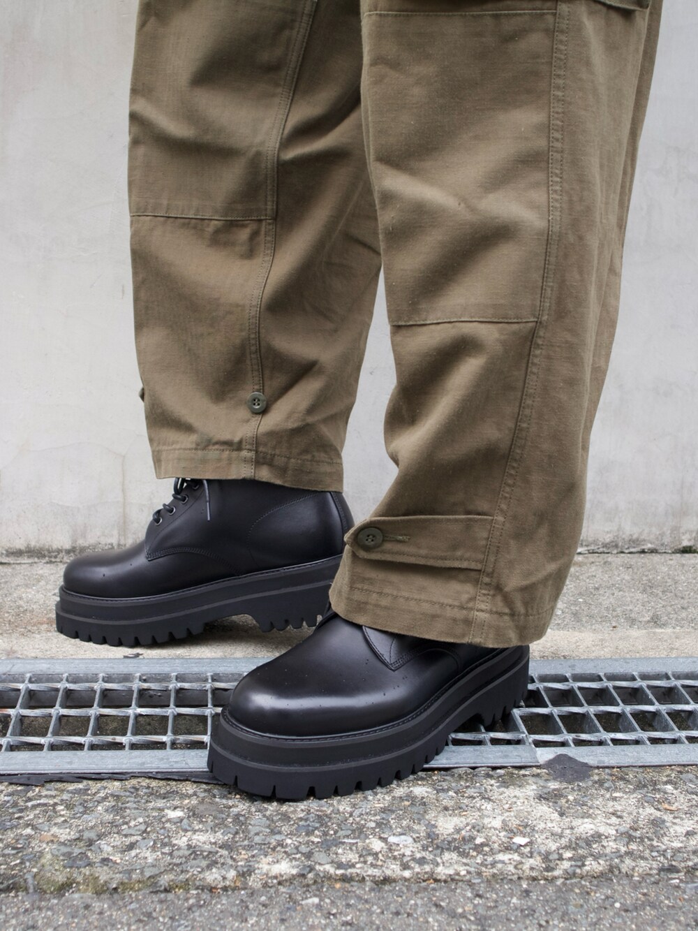ブラック系のトートバッグ、ブラック系のブーツを着用したメンズの秋コーディネートの4枚目の写真