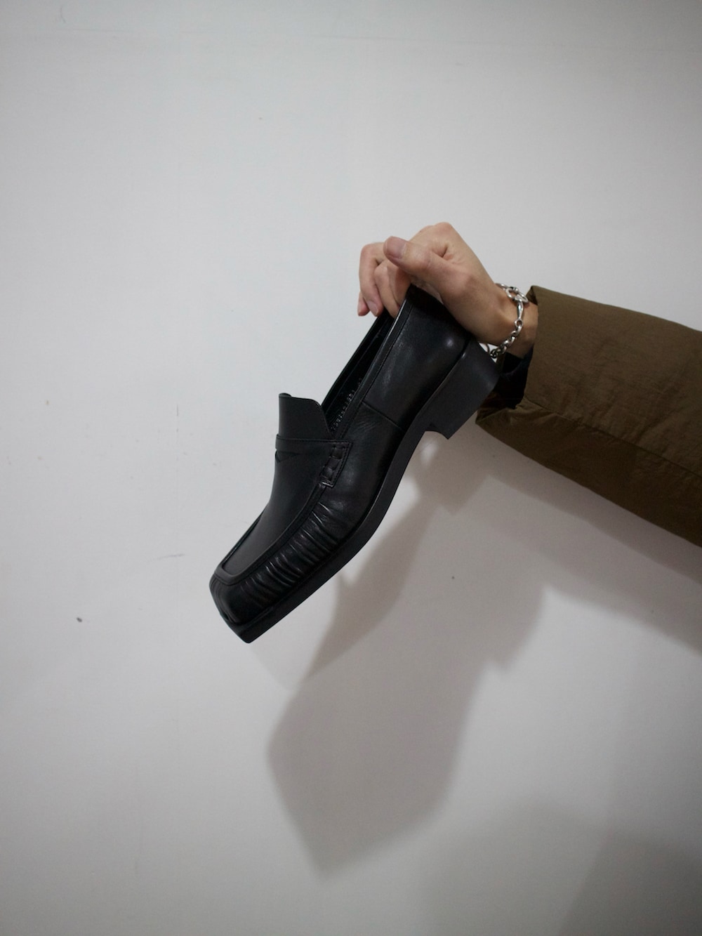 ブラウン系のダウンジャケット/コート、ブラック系のスリッポンを着用したメンズの冬コーディネートの2枚目の写真