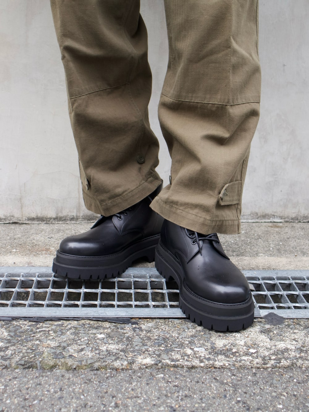 ブラック系のトートバッグ、ブラック系のブーツを着用したメンズの秋コーディネートの3枚目の写真