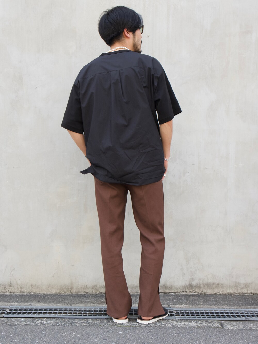 ブラック系のTシャツ/カットソー、ブラック系のサンダルを着用したメンズの春コーディネートの2枚目の写真