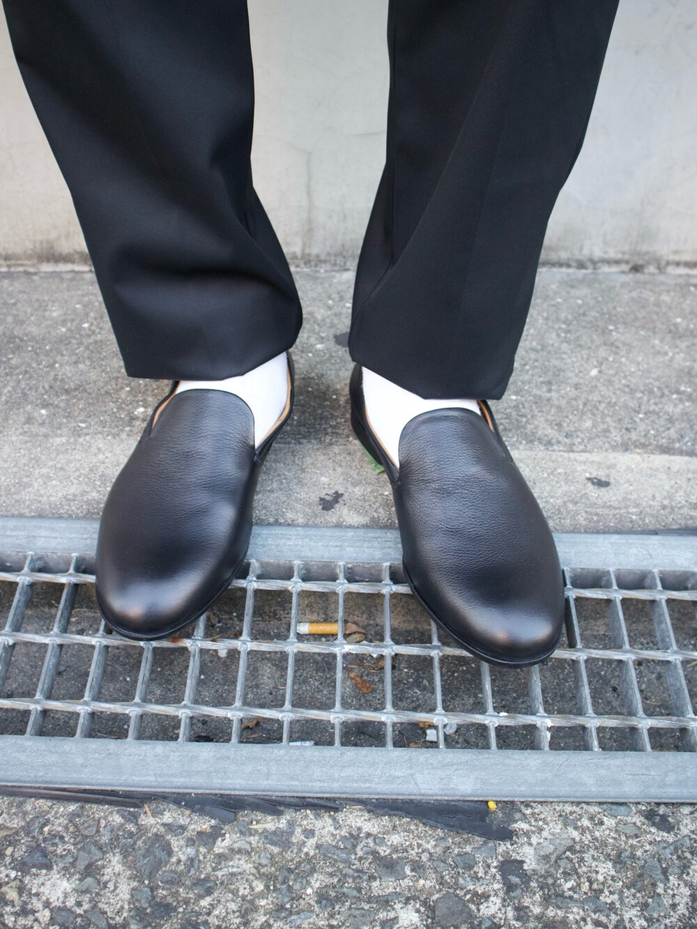 ブラック系のトートバッグ、ブラック系のスリッポンを着用したメンズの春コーディネートの3枚目の写真