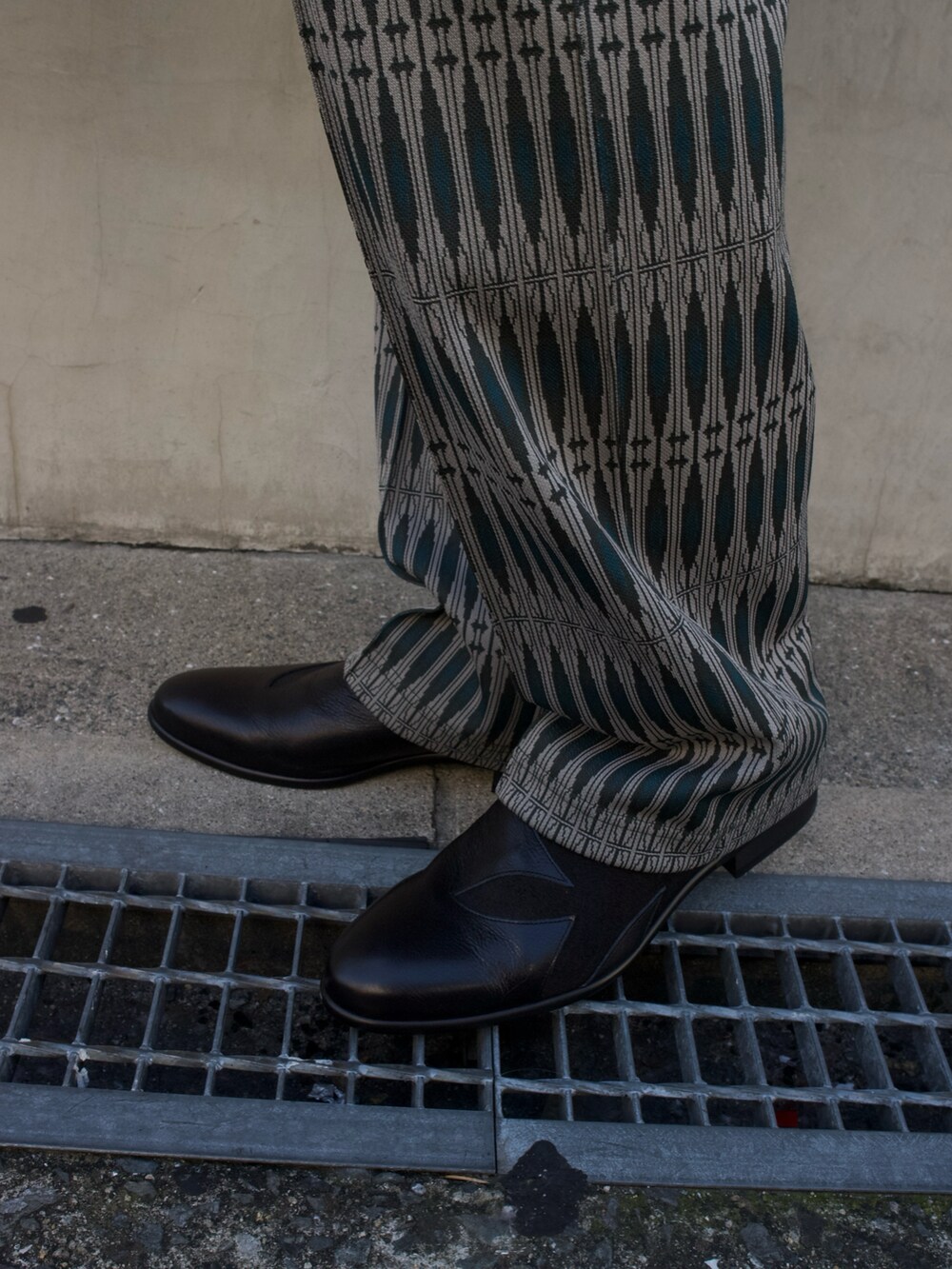 グリーン系のトートバッグ、ブラック系のローファーを着用したメンズの春コーディネートの2枚目の写真