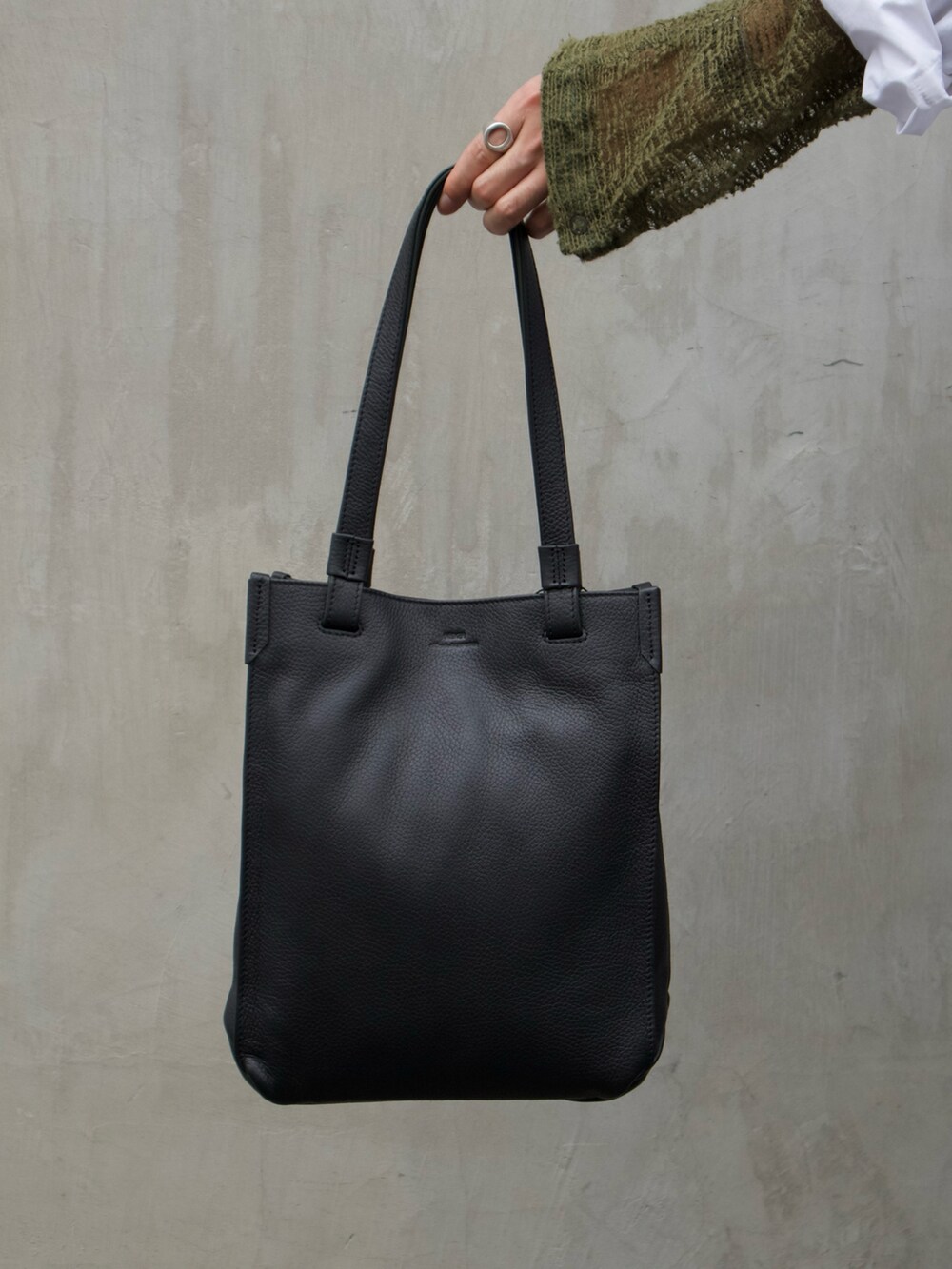 グリーン系のトートバッグ、ブラック系のサンダルを着用したメンズの夏コーディネートの2枚目の写真