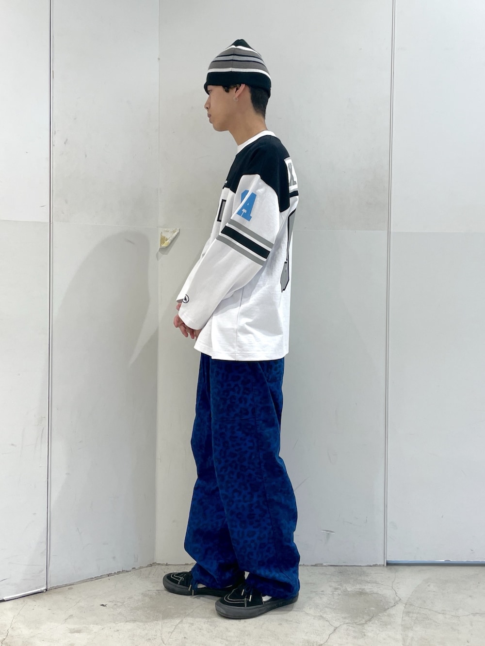 ホワイト系のTシャツ/カットソー、ブルー系のその他パンツ、ブラック系のニットキャップ/ビーニーを着用したメンズの春コーディネートの2枚目の写真