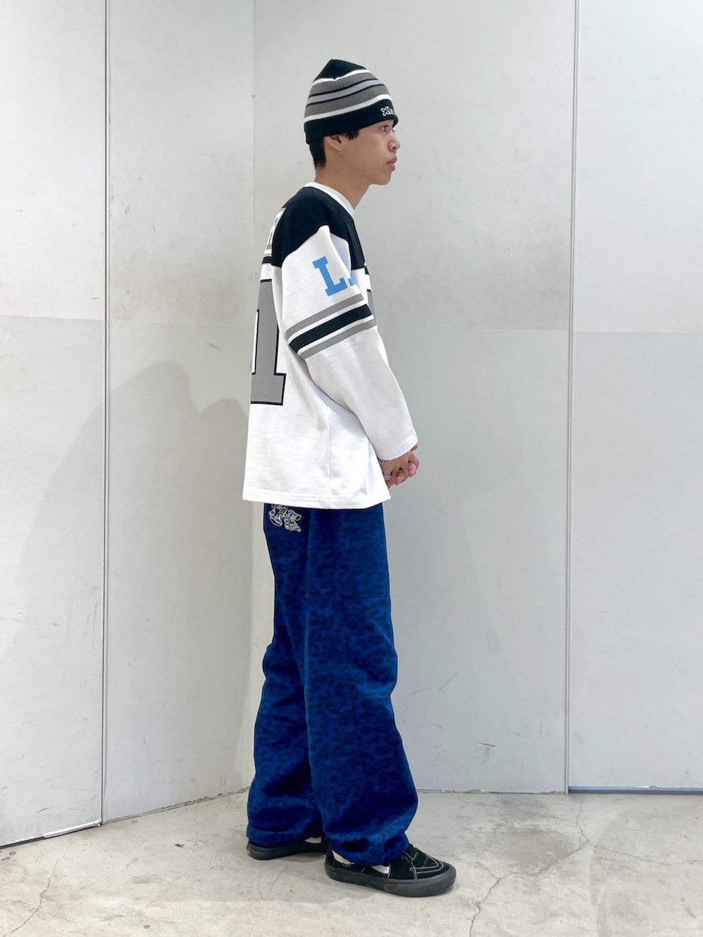 ホワイト系のTシャツ/カットソー、ブルー系のその他パンツ、ブラック系のニットキャップ/ビーニーを着用したメンズの春コーディネートの4枚目の写真