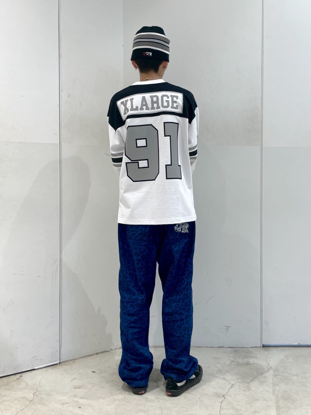 ホワイト系のTシャツ/カットソー、ブルー系のその他パンツ、ブラック系のニットキャップ/ビーニーを着用したメンズの春コーディネートの3枚目の写真