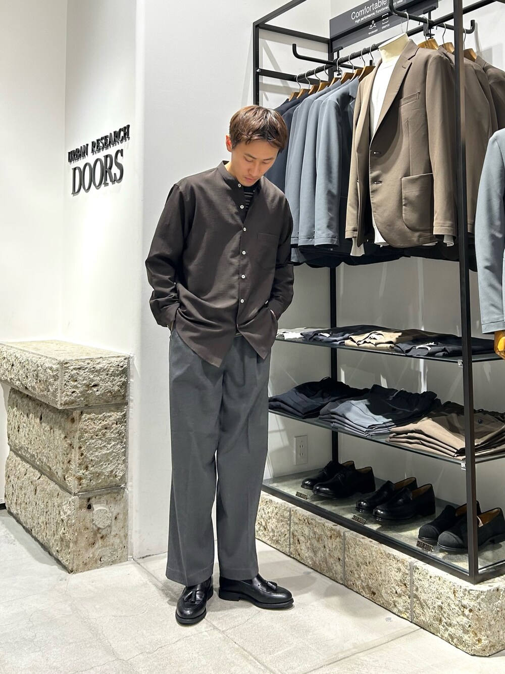 ブラウン系のシャツ/ブラウス、グレー系のその他パンツ、ブラック系のドレスシューズを着用したメンズの春コーディネートの2枚目の写真