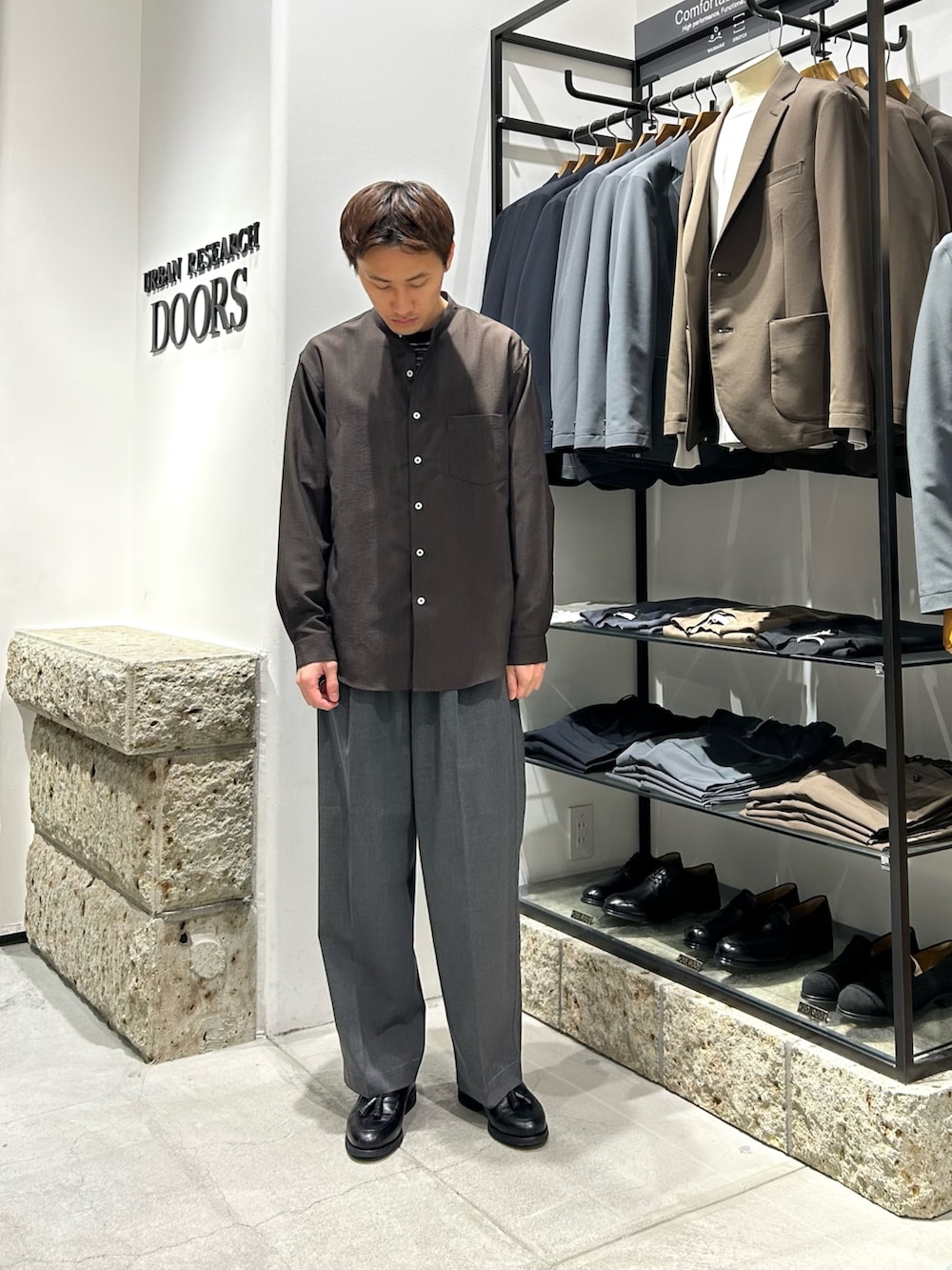 ブラウン系のシャツ/ブラウス、グレー系のその他パンツ、ブラック系のドレスシューズを着用したメンズの春コーディネートの3枚目の写真