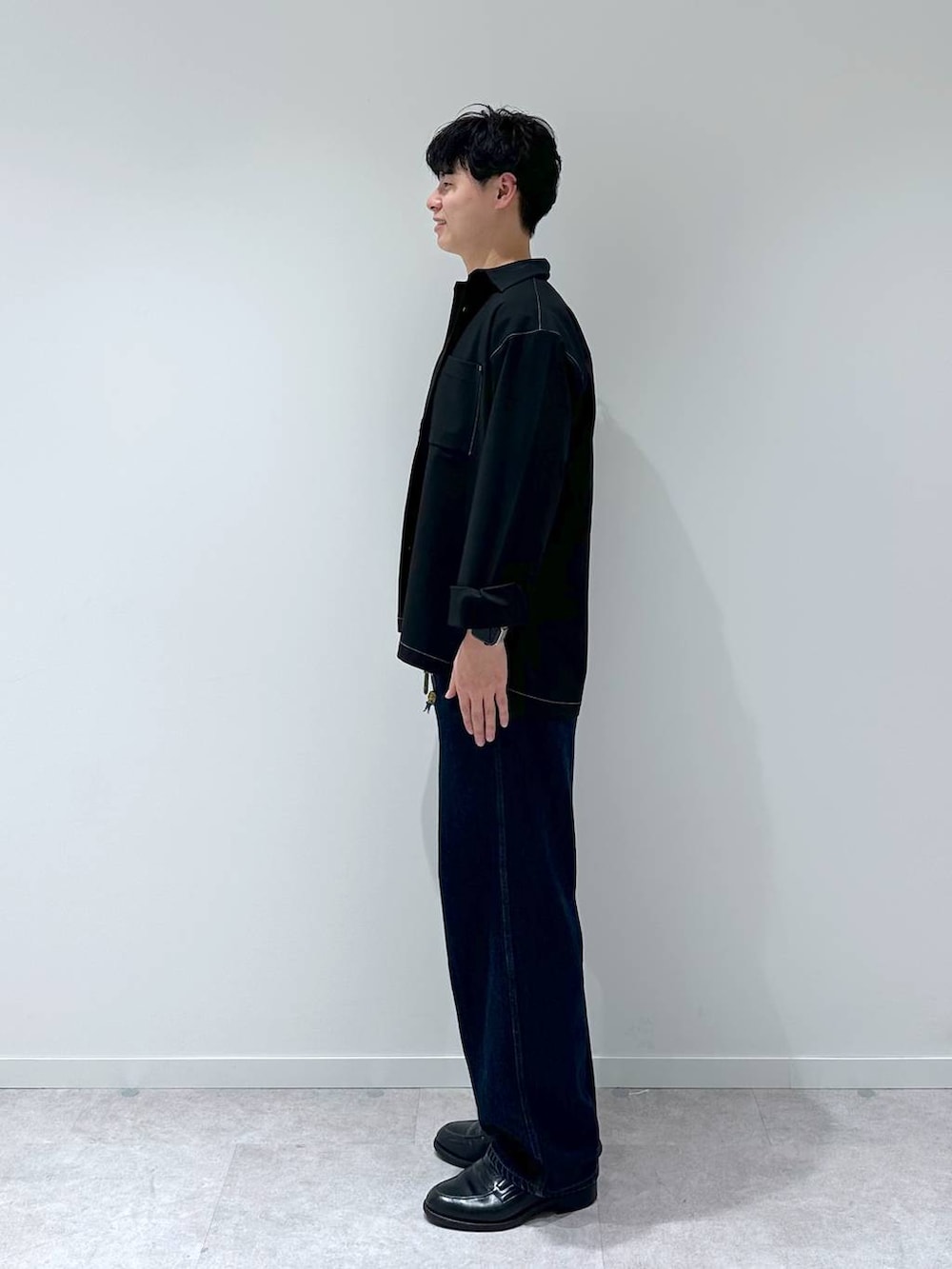 ホワイト系のTシャツ/カットソー、ブルー系のデニムパンツ、ブラック系のシャツ/ブラウスを着用したメンズの秋コーディネートの4枚目の写真