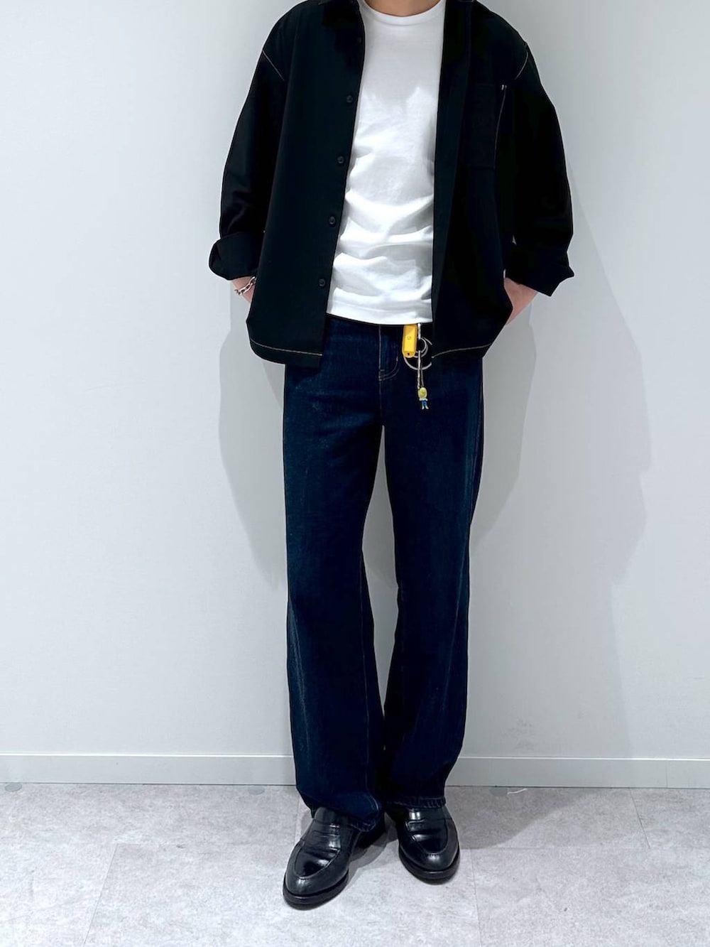 ホワイト系のTシャツ/カットソー、ブルー系のデニムパンツ、ブラック系のシャツ/ブラウスを着用したメンズの秋コーディネートの6枚目の写真