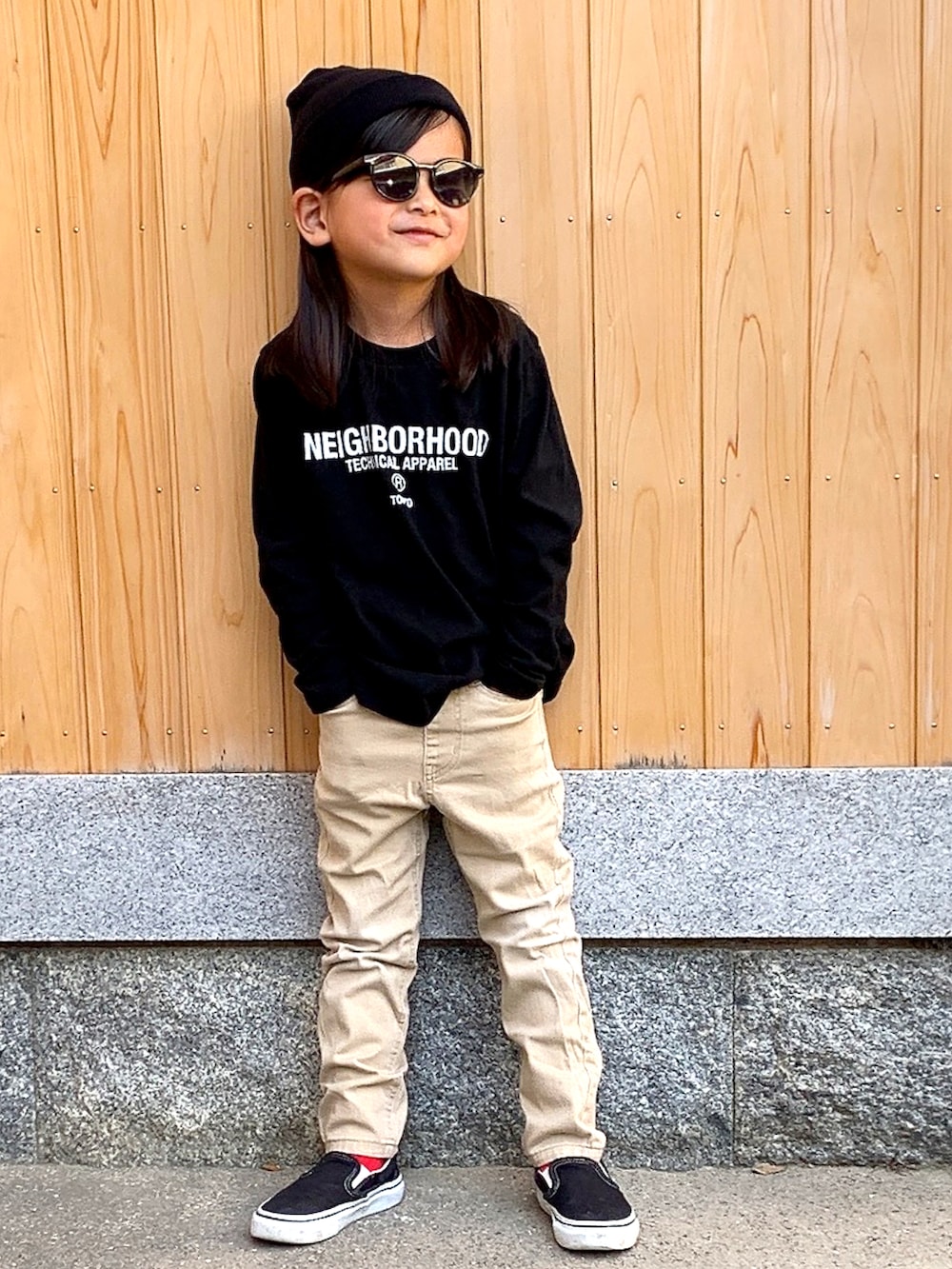 ブラック系のTシャツ/カットソー、ベージュ系のチノパンツ、ブラック系のスニーカーを着用したキッズの春コーディネートの2枚目の写真