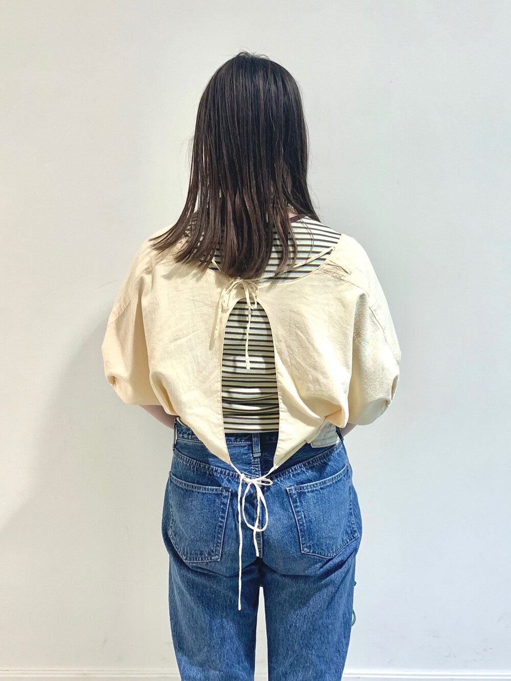 ベージュ系のシャツ/ブラウス、グリーン系のTシャツ/カットソー、ブルー系のデニムパンツを着用したレディースの夏コーディネートの3枚目の写真