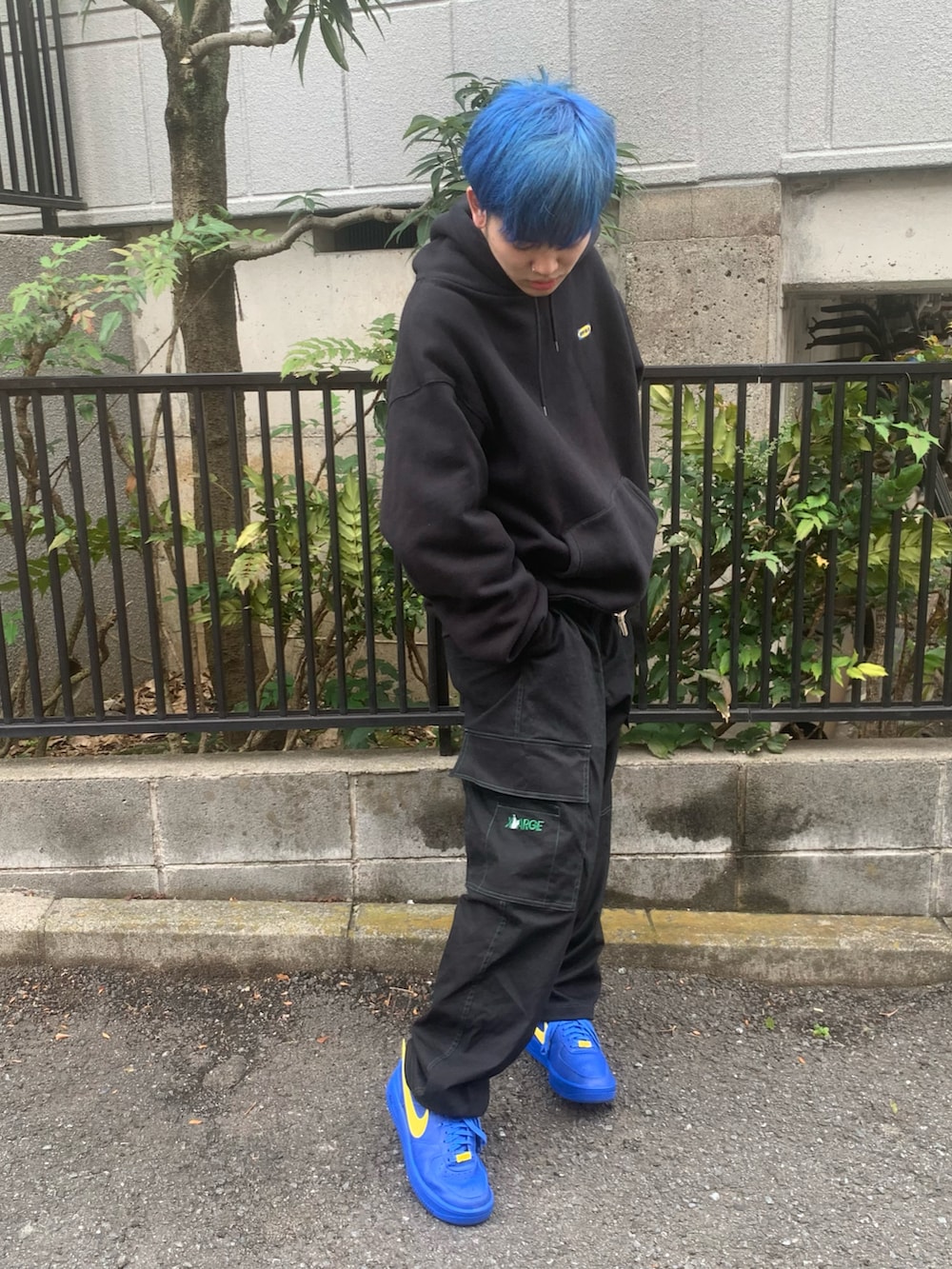 ブラック系のカーゴパンツ、イエロー系のスニーカー、ブラック系のパーカーを着用したメンズの冬コーディネートの2枚目の写真