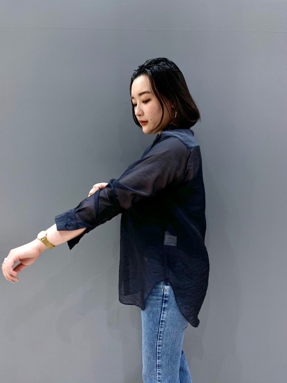 ブルー系のシャツ/ブラウス、ブルー系のデニムパンツ、ブラック系のショルダーバッグを着用したレディースの冬コーディネートの4枚目の写真