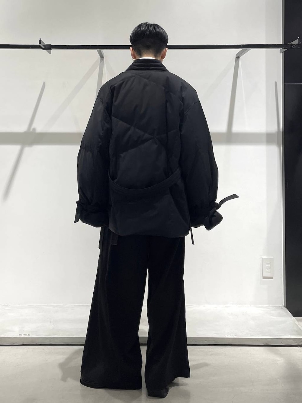 ブラック系のスラックス、ブラック系のローファー、ブラック系のボディバッグ/ウエストポーチを着用したメンズの冬コーディネートの2枚目の写真