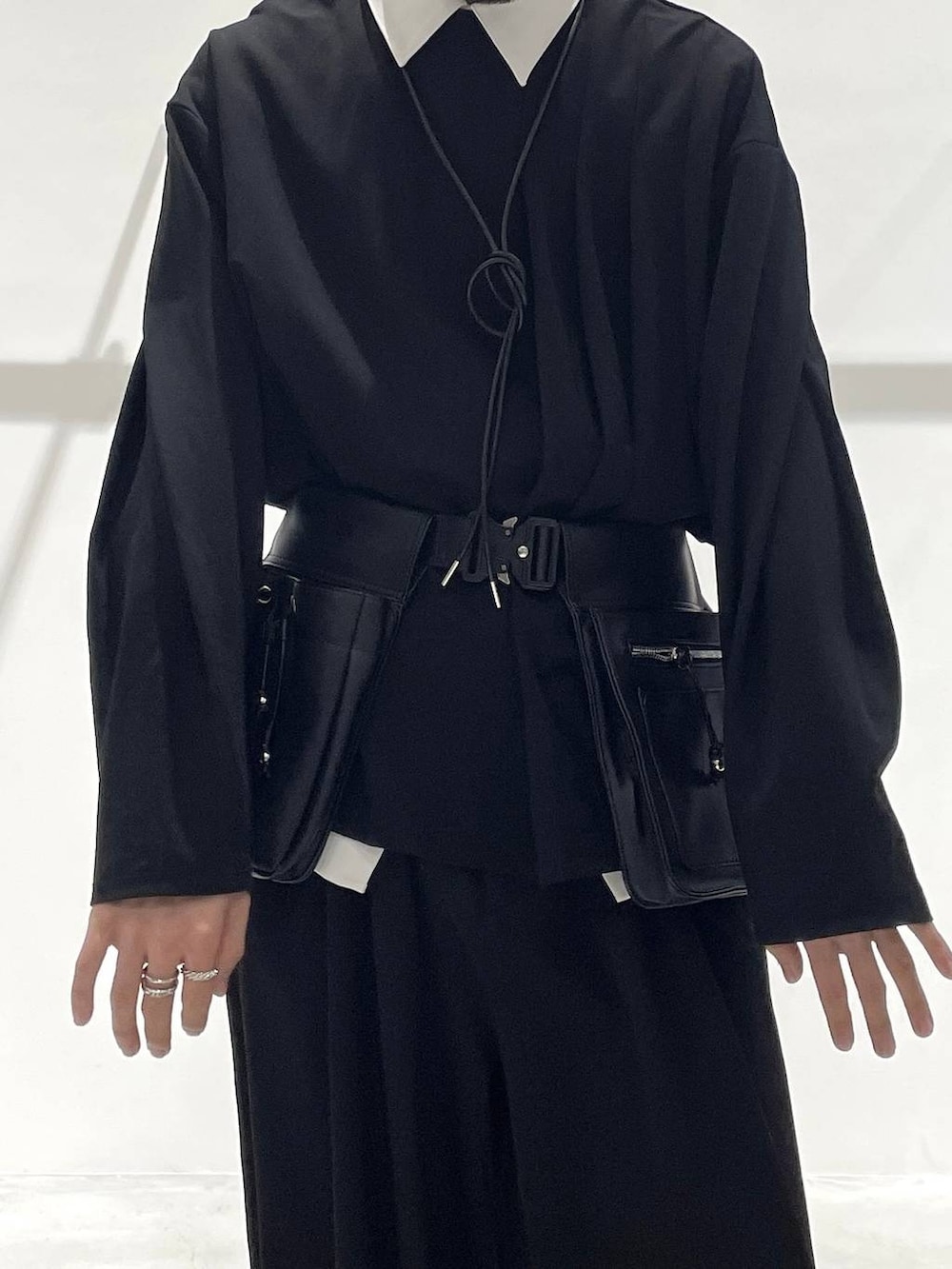 ブラック系のスラックス、ブラック系のローファー、ブラック系のボディバッグ/ウエストポーチを着用したメンズの冬コーディネートの6枚目の写真