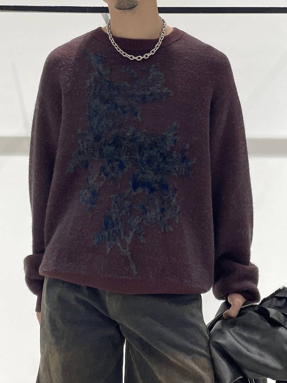 グレー系のブルゾン、レッド系のニット/セーター、ブラック系のドレスシューズを着用したメンズの秋コーディネートの4枚目の写真