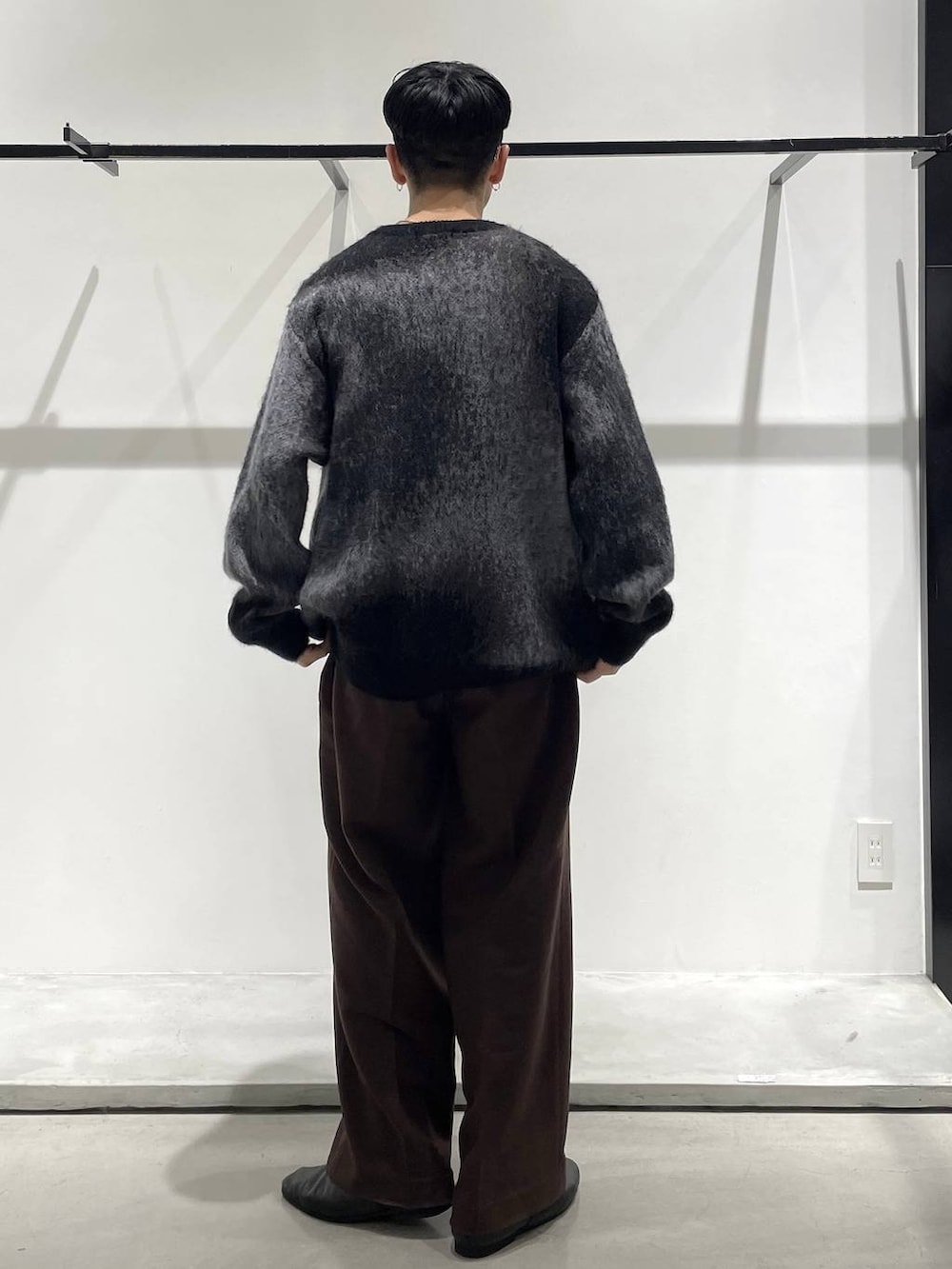 ブラック系のバレエシューズ、ブラック系のニット/セーター、シルバー系のネックレスを着用したメンズの冬コーディネートの2枚目の写真