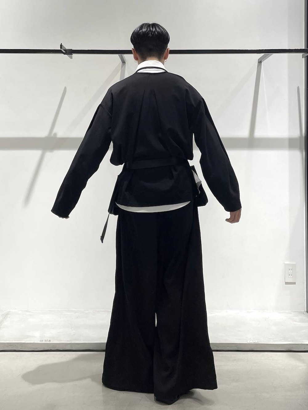 ブラック系のスラックス、ブラック系のローファー、ブラック系のボディバッグ/ウエストポーチを着用したメンズの冬コーディネートの4枚目の写真