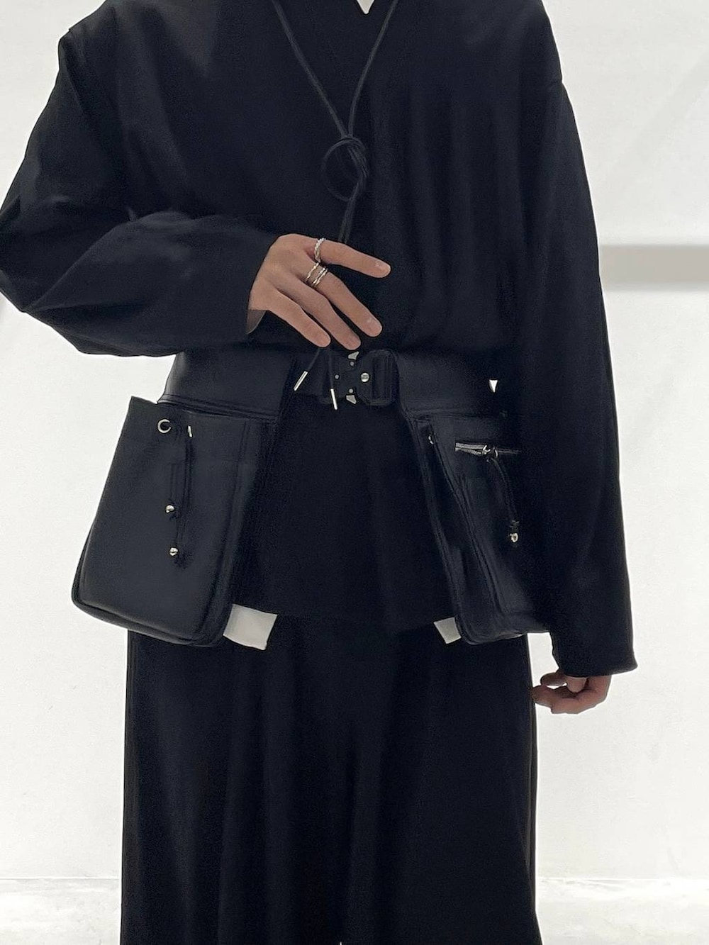 ブラック系のスラックス、ブラック系のローファー、ブラック系のボディバッグ/ウエストポーチを着用したメンズの冬コーディネートの5枚目の写真