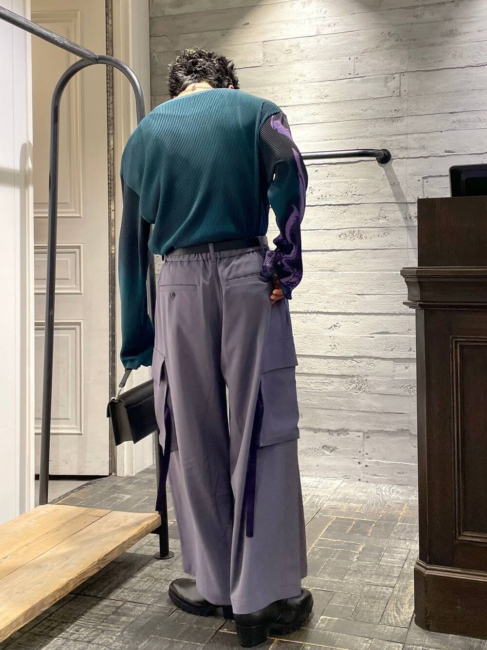 ブラック系のショルダーバッグ、ブラック系のドレスシューズ、グリーン系のTシャツ/カットソーを着用したメンズの春コーディネートの2枚目の写真