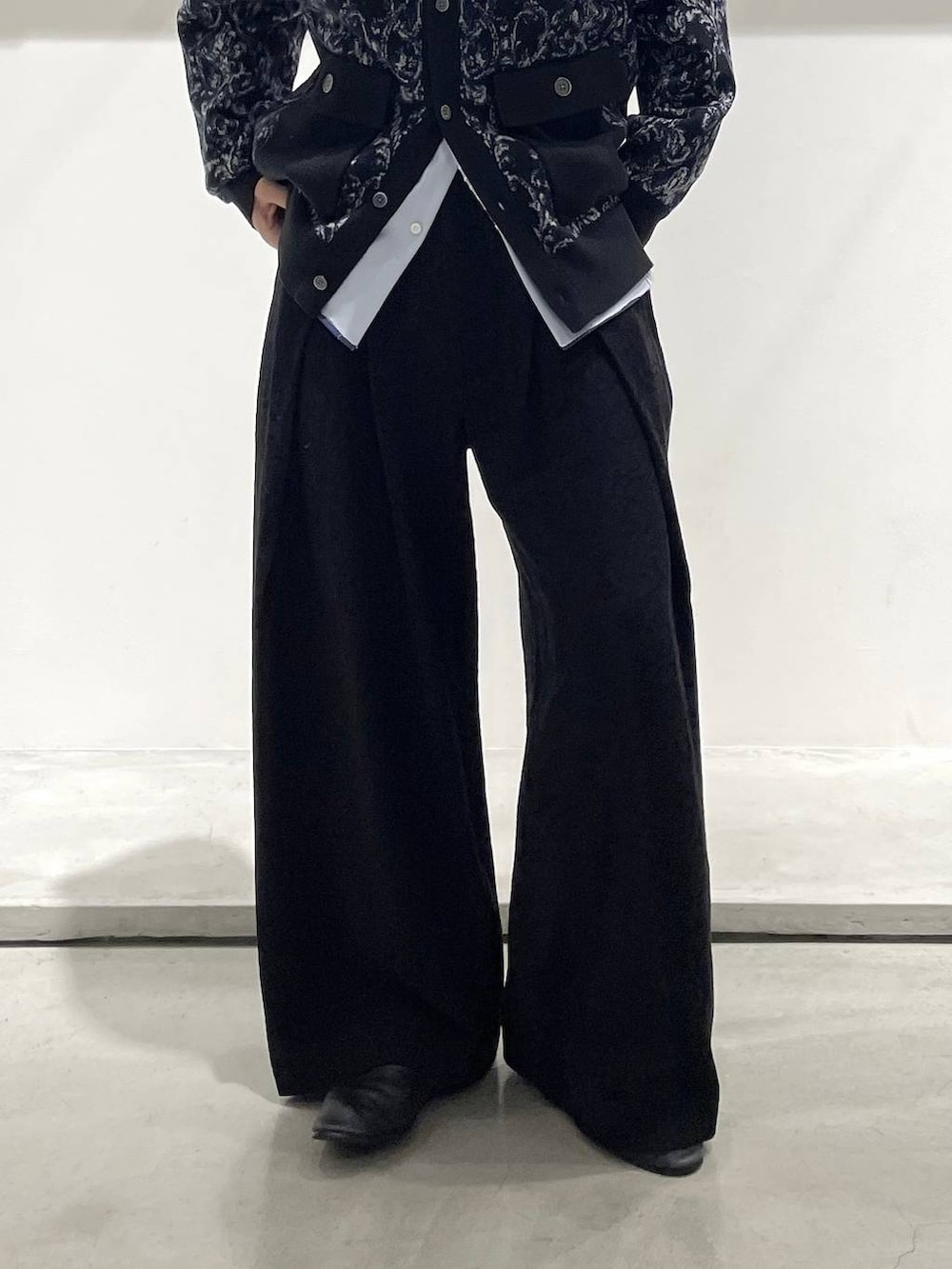 ブラック系のステンカラーコート、ブラック系のバレエシューズ、ブルー系のシャツ/ブラウスを着用したメンズの冬コーディネートの5枚目の写真